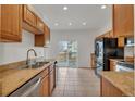 Eat-in kitchen featuring tile floors, stainless steel appliances, and wood cabinets at 1552 Live Oak Rd, Castle Rock, CO 80104
