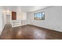 Bright living room featuring hardwood floors, built-in shelving, and large windows at 757 Norfolk Way, Aurora, CO 80011