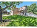 A beautiful two-story home with a large, green lawn and mature trees at 10289 Dresden St, Firestone, CO 80504
