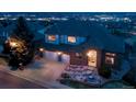 Aerial view of a red brick two story home with 3-car garage on large lot taken at dusk at 16261 W Ellsworth Ave, Golden, CO 80401