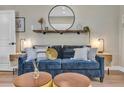 Living room featuring a comfortable blue sofa with decoratively-pillowed cushions and rustic shelving at 3219 W 19Th Ave # 4, Denver, CO 80204