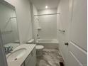 Clean, all-white bathroom with a tub and shower combination at 16562 E 109Th Ave, Commerce City, CO 80022