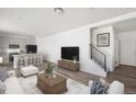 Open-concept living room and kitchen with modern furnishings, hardwood flooring, and staircase at 22123 E 38Th Pl, Aurora, CO 80019