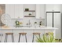 Modern kitchen featuring white cabinets, quartz countertops, sleek island, and stainless steel appliances at 5462 S Cedar St, Littleton, CO 80120
