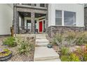 A close-up of the home's red front door, stone accents, and concrete steps at 16546 Umatilla Place, Broomfield, CO 80023