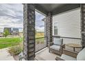 Covered front porch with comfortable outdoor seating and views of the community at 16546 Umatilla Place, Broomfield, CO 80023