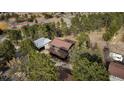 Expansive aerial view showcasing the home's setting nestled amongst mature trees at 3046 S Alpine Dr, Evergreen, CO 80439
