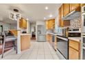 Bright kitchen featuring stainless steel appliances, tile flooring and a breakfast bar at 3046 S Alpine Dr, Evergreen, CO 80439