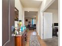 Welcoming entryway with hardwood floors, a console table with decor, and views into the living room and an office space at 5563 S Elk Ct, Aurora, CO 80016