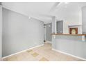 Open dining area with neutral walls and tile flooring, adjacent to a bar and view of entry at 12154 E Virginia Dr, Aurora, CO 80012