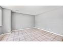 Simple living space with neutral walls, tile flooring, and ample natural light from a window at 12154 E Virginia Dr, Aurora, CO 80012