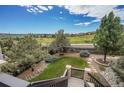 Scenic backyard featuring lush greenery, mature trees, and a beautiful garden area at 2314 Fairway Wood Cir, Castle Rock, CO 80109