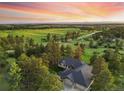 Panoramic aerial view of a home nestled among trees and green fields, with mountains visible in the distance at 121 County Road 146, Elizabeth, CO 80107