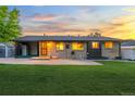Backyard view of a brick home with a patio and green space at 6114 Miller St, Arvada, CO 80004