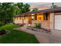 Inviting front entrance with brick facade, walkway, and manicured landscaping at 6114 Miller St, Arvada, CO 80004