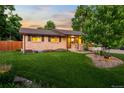 Well-manicured lawn and landscaped garden beds enhance this home's curb appeal at 6114 Miller St, Arvada, CO 80004