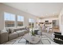 Bright, open living space with large windows, modern furnishings, and seamless flow to the dining and kitchen area at 19089 E 94Th Pl, Commerce City, CO 80022