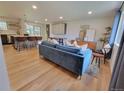 Bright open-concept living room featuring hardwood floors, a modern sofa, and a view to the kitchen at 315 E 112Th Dr, Northglenn, CO 80233