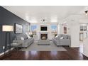 Open-concept living room with ample natural light, a fireplace, and hardwood floors at 2791 S Bahama Ct, Aurora, CO 80013