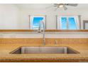 The kitchen features an undermount stainless steel sink and a high-arc faucet under large bright windows at 15475 Andrews Dr # 310, Denver, CO 80239