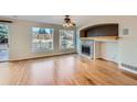 Bright and spacious living room featuring hardwood floors, a fireplace, and large windows overlooking the backyard at 3938 Lazy K Dr, Castle Rock, CO 80104