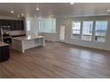 Bright, open-concept living area with hardwood floors and an adjacent kitchen at 7307 Waterleaf Trl, Littleton, CO 80125