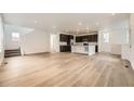 Open-concept living area features wood floors and recessed lighting, seamlessly flowing into the kitchen at 7307 Waterleaf Trl, Littleton, CO 80125