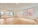 Bright living room featuring hardwood floors and a large window showing outdoor views at 7307 Waterleaf Trl, Littleton, CO 80125