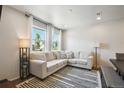 Inviting living room with a large sectional sofa, striped rug, and bright windows for natural light at 19221 E 65Th Ave, Denver, CO 80249