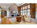 Cozy living room with brick fireplace, wood paneling, and comfortable seating at 6414 E Stanford Ave, Cherry Hills Village, CO 80111