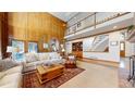 Bright living room with wood paneled walls, spiral staircase, and upper-level balcony at 6414 E Stanford Ave, Cherry Hills Village, CO 80111