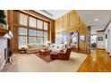 Spacious living room boasts wooden paneling, large windows, and a cozy seating area with sofas at 6414 E Stanford Ave, Cherry Hills Village, CO 80111