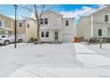 Inviting two-story home featuring a one-car garage, complemented by a snow-covered front yard and driveway at 11848 W Tufts Pl, Morrison, CO 80465