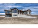 Exterior of a new home on a sloped lot with modern design elements and gray siding at 1740 Joseph Cir, Elizabeth, CO 80107