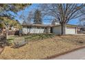 Charming exterior view featuring a bench under a mature tree, complemented by a well-maintained lawn at 2955 E Caley Ave, Centennial, CO 80121