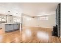 Open-concept living area featuring hardwood floors, a stone fireplace, and a modern kitchen island at 2955 E Caley Ave, Centennial, CO 80121