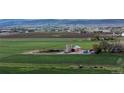 Scenic aerial shot of farm land, buildings, and surrounding greenery with picturesque landscape at 1805 W County Road 8, Berthoud, CO 80513