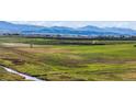 Beautiful landscape view of the open field with a small stream and mountains in the background at 1805 W County Road 8, Berthoud, CO 80513