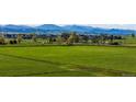 A large beautiful green open field with a mountain view and houses in the background at 1805 W County Road 8, Berthoud, CO 80513