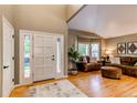 Inviting home entryway with gleaming hardwood floors and a cozy living room featuring plush seating and bright natural light at 5473 W Prentice Ct, Littleton, CO 80123