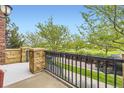 A balcony view featuring wrought iron railing overlooking mature trees and green space at 10311 Belvedere Ln, Lone Tree, CO 80124