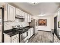Modern kitchen boasts white cabinetry, black countertops, and stainless steel appliances at 8361 Mason Cir, Westminster, CO 80031