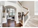 Open foyer featuring hardwood floors, staircase, and arched doorway to the living area at 1932 Sandhurst Dr, Castle Rock, CO 80104