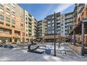 Exterior courtyard with contemporary sculpture, landscaping, benches, and walkway surrounded by luxury condos with glass balconies at 20 Wilcox St # 518, Castle Rock, CO 80104