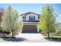 Charming two-story home showcasing blossoming trees and a well-maintained front yard at 15194 W Washburn Ave, Lakewood, CO 80228
