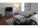 Cozy living room features wood floors, a tufted ottoman, and a comfortable sofa at 569 Alton Way # E, Denver, CO 80230
