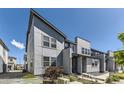 Contemporary two-story townhouse with clean lines, large windows, and professional landscaping at 16057 E 47Th Pl, Denver, CO 80239
