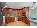 Kitchen with wood cabinets, countertops, stainless steel appliances, and wood flooring at 8100 E Union Ave # 614, Denver, CO 80237