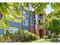 Charming multi-level condo building with brick accents, balconies, and lush green landscaping at 804 Summer Hawk Dr # 3202, Longmont, CO 80504