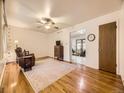 Cozy living room with hardwood floors, ceiling fan, and open view to dining area at 5721 Everett St, Arvada, CO 80002